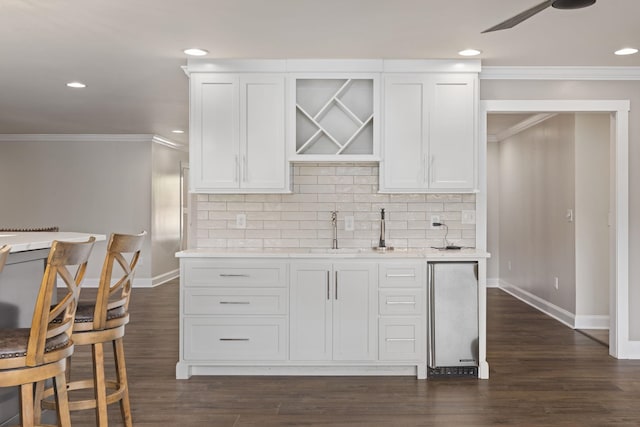 kitchen with light countertops, backsplash, and white cabinetry