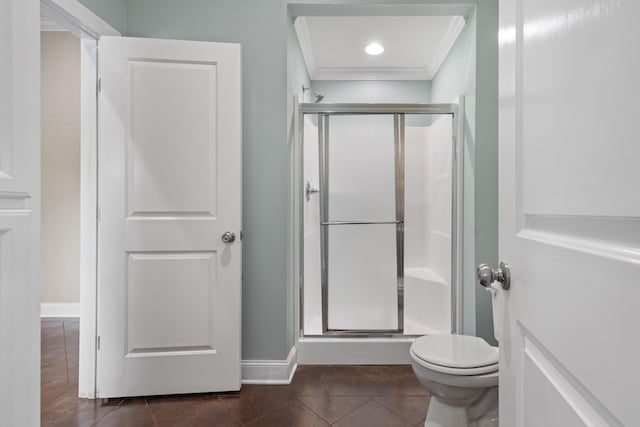 full bath with a stall shower, baseboards, toilet, tile patterned floors, and crown molding