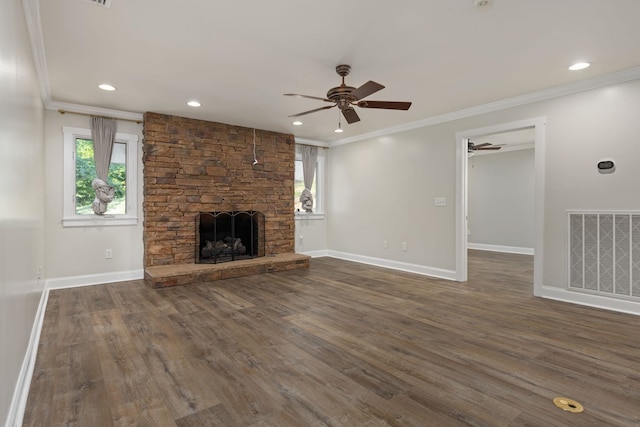 unfurnished living room with a fireplace, visible vents, dark wood finished floors, and ornamental molding