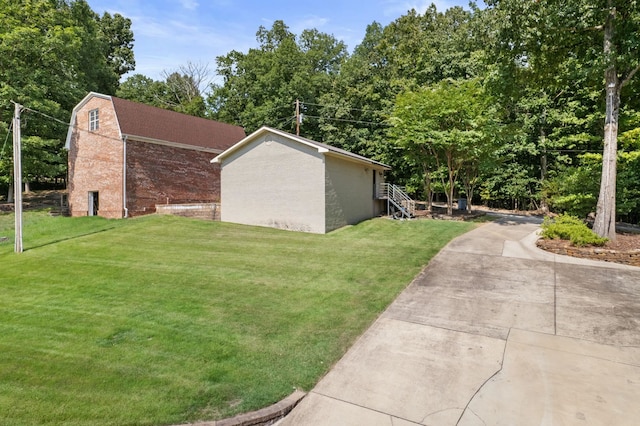 view of side of property featuring a lawn and a gambrel roof