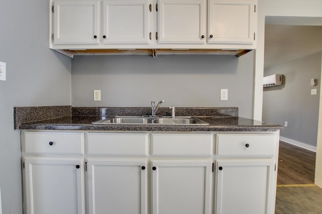 kitchen with wood-type flooring, sink, and white cabinets