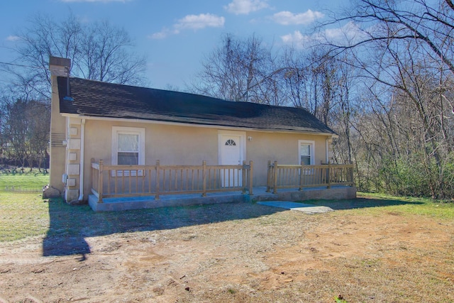 view of front facade featuring a wooden deck and a front lawn