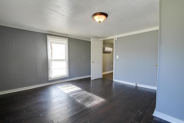 spare room featuring dark hardwood / wood-style floors and a wall mounted air conditioner