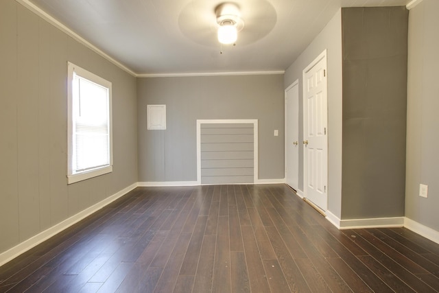 empty room featuring ornamental molding and dark hardwood / wood-style flooring