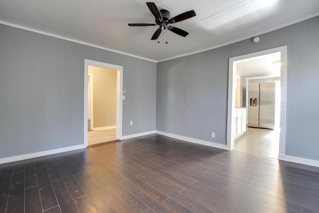 empty room with crown molding, dark wood-type flooring, and ceiling fan