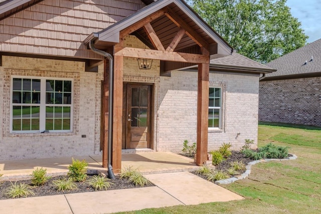 view of exterior entry featuring a lawn