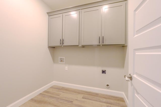 laundry room featuring cabinets, hookup for a gas dryer, light hardwood / wood-style floors, hookup for a washing machine, and hookup for an electric dryer