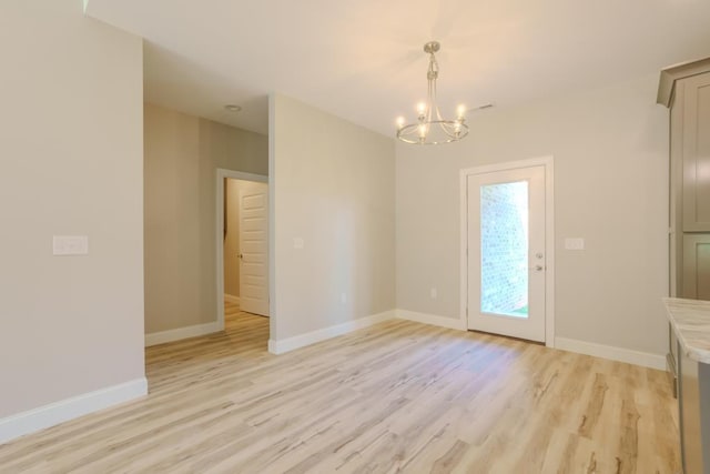 unfurnished dining area with a notable chandelier and light wood-type flooring