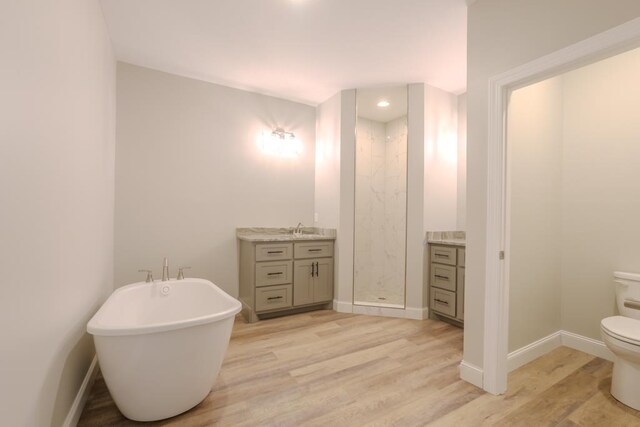 full bathroom featuring vanity, hardwood / wood-style floors, plus walk in shower, and toilet