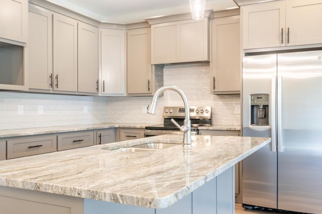 kitchen with light stone countertops, appliances with stainless steel finishes, and gray cabinetry