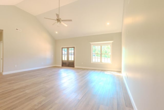 unfurnished living room with light hardwood / wood-style flooring, high vaulted ceiling, french doors, and ceiling fan