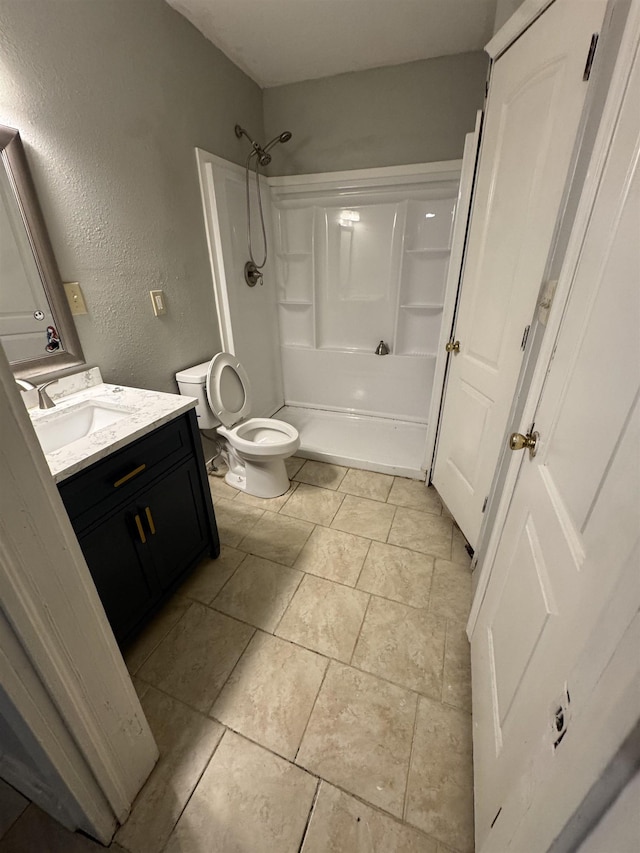  - full bath with vanity, a textured wall, and shower / tub combination