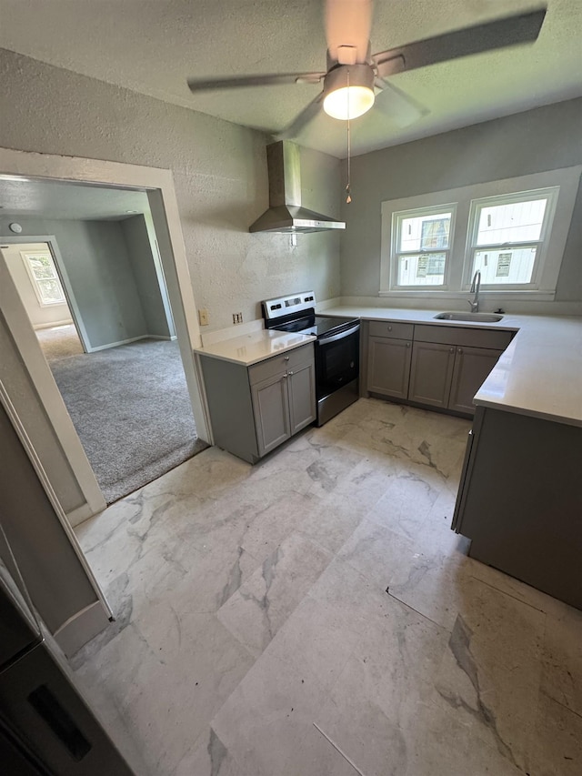  - kitchen with stainless steel electric range oven, wall chimney exhaust hood, gray cabinets, a textured wall, and a ceiling fan