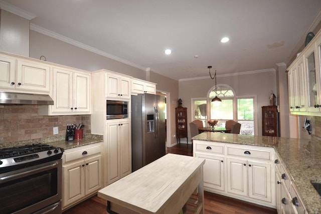 kitchen with backsplash, light stone countertops, ornamental molding, appliances with stainless steel finishes, and dark hardwood / wood-style flooring