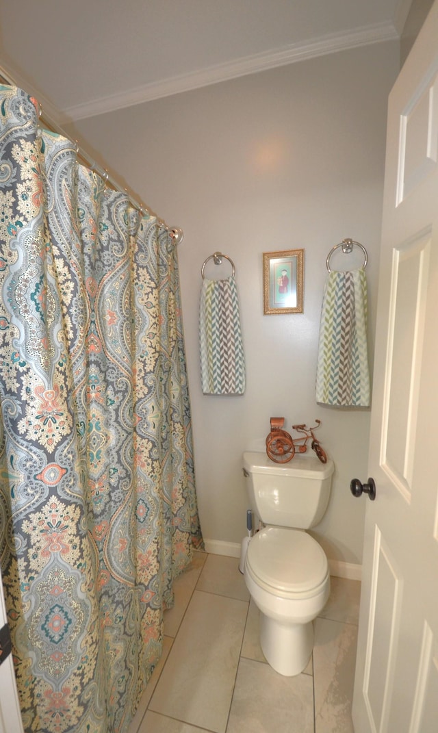 bathroom with tile patterned floors, crown molding, and toilet