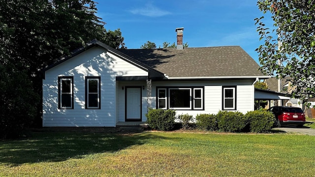 bungalow-style home with a carport and a front lawn