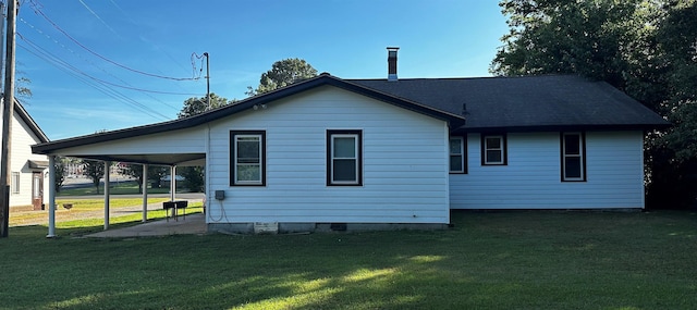 back of house with a yard and a carport