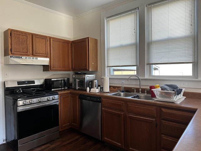 kitchen with appliances with stainless steel finishes, dark wood-type flooring, crown molding, and sink