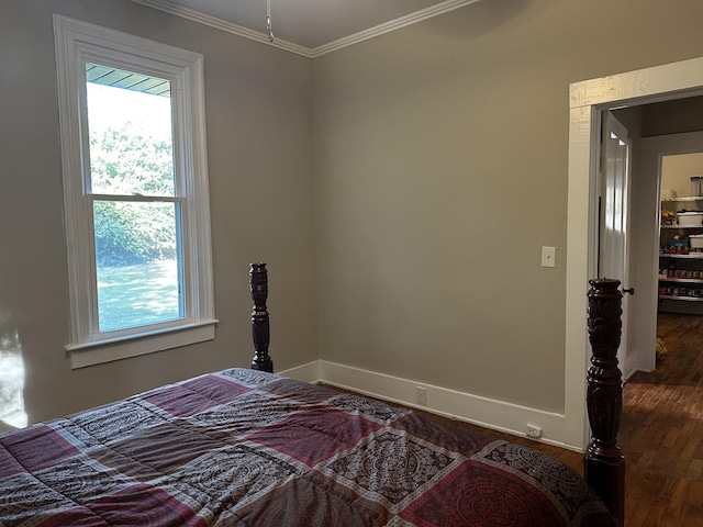 bedroom with dark hardwood / wood-style flooring and crown molding