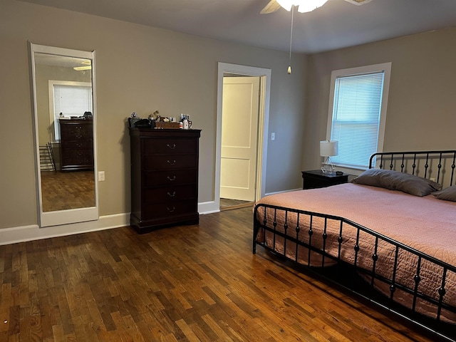 bedroom featuring ceiling fan, dark hardwood / wood-style floors, and multiple windows