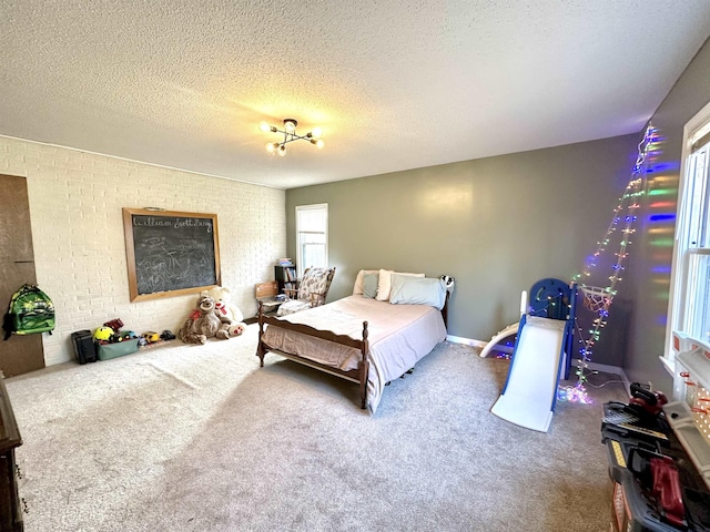 carpeted bedroom with brick wall and a textured ceiling