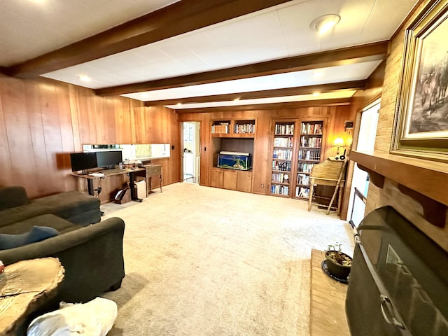 carpeted living room featuring beamed ceiling and wood walls