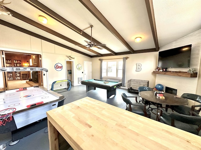 playroom featuring concrete flooring, vaulted ceiling with beams, pool table, ceiling fan, and a fireplace