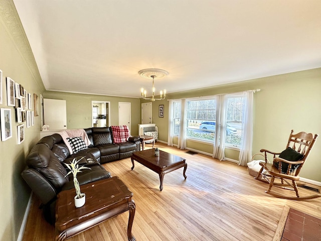 living room with an inviting chandelier and light hardwood / wood-style flooring