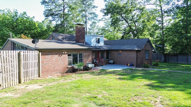 rear view of house featuring a yard and a patio