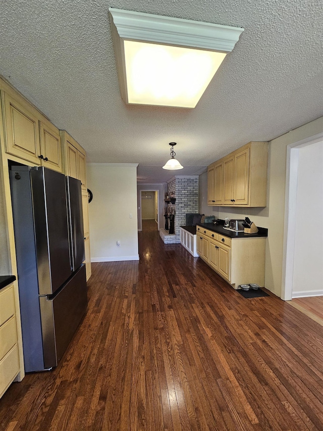  - kitchen with freestanding refrigerator, dark countertops, dark wood-style flooring, baseboards, and a textured ceiling