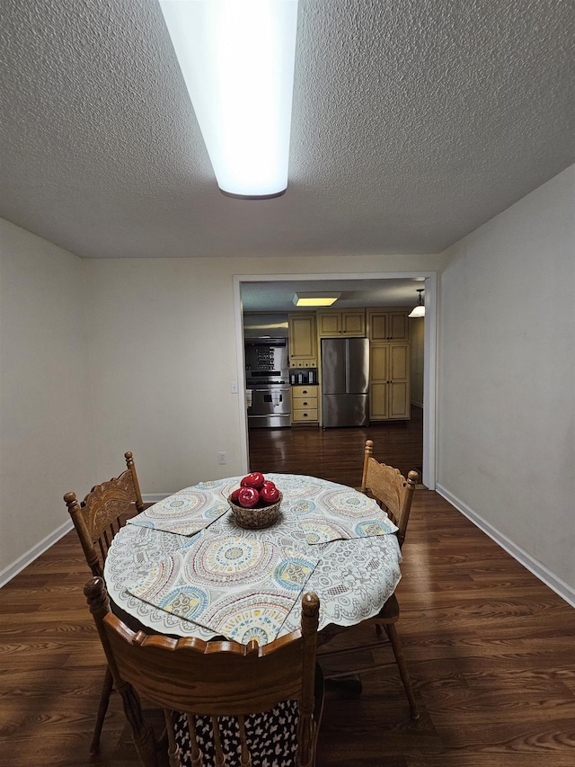  - dining room featuring a textured ceiling, dark wood-style floors, and baseboards