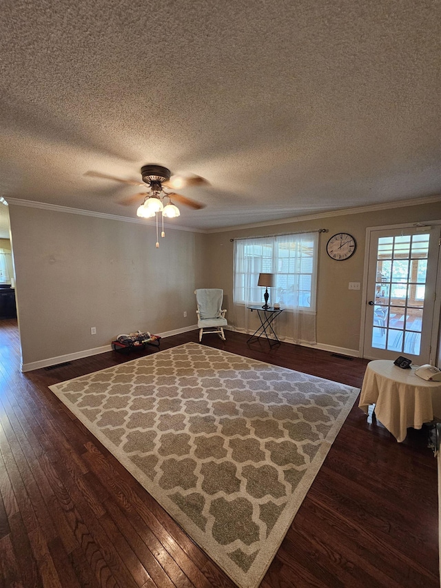  - sitting room featuring dark wood-type flooring, crown molding, a textured ceiling, ceiling fan, and baseboards