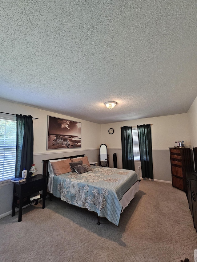  - bedroom with multiple windows, carpet, a textured ceiling, and baseboards