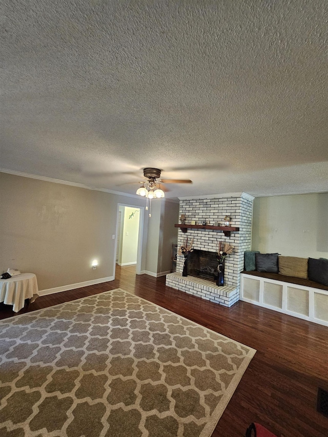  - unfurnished living room featuring a ceiling fan, wood finished floors, a textured ceiling, a brick fireplace, and baseboards