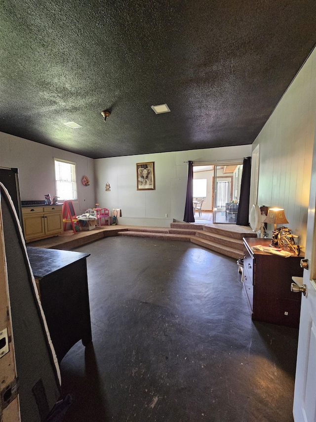  - interior space with a textured ceiling and concrete floors