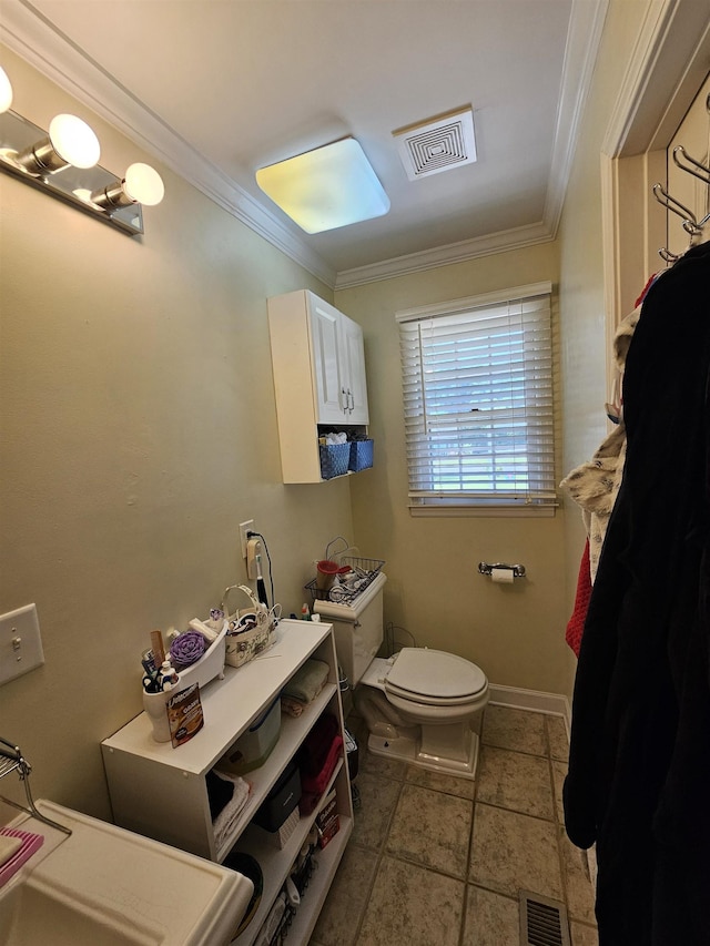 - half bath with ornamental molding, toilet, and stone tile flooring