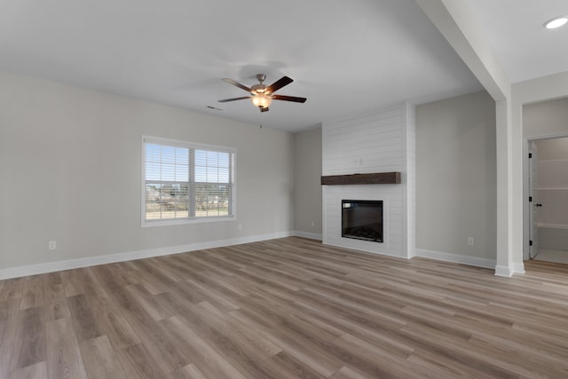 unfurnished living room with a fireplace, light hardwood / wood-style floors, and ceiling fan