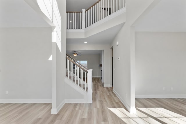 entrance foyer with a high ceiling, light wood-type flooring, and ceiling fan