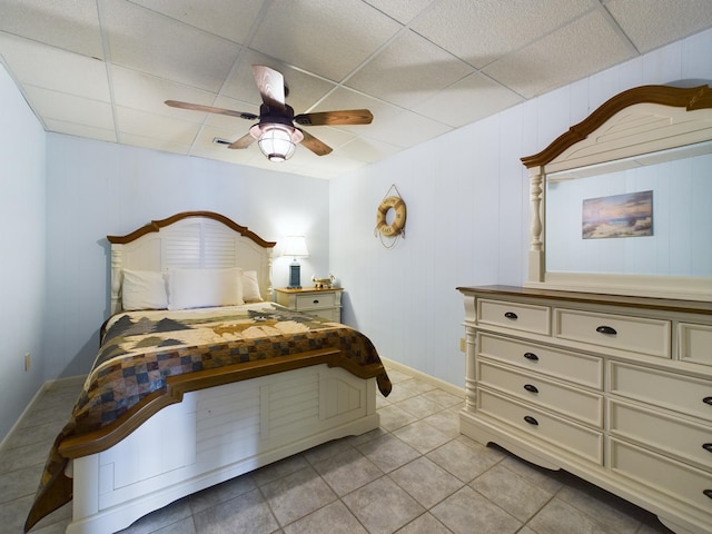 bedroom featuring a paneled ceiling, ceiling fan, and light tile patterned flooring