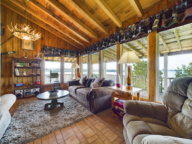 living room with wooden ceiling, vaulted ceiling with beams, a notable chandelier, wooden walls, and a water view