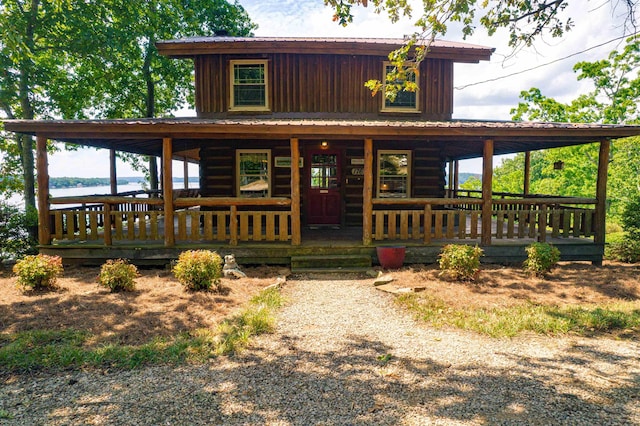 view of front of property with covered porch and a water view