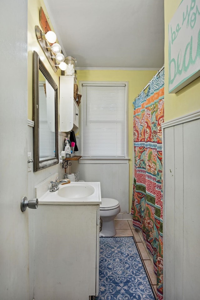 bathroom featuring tile patterned flooring, vanity, crown molding, and toilet