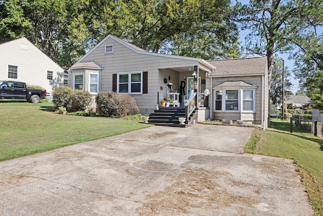 view of front of house with covered porch, a front yard, and fence