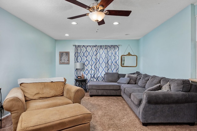 carpeted living room featuring ceiling fan and a textured ceiling