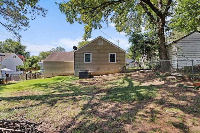 rear view of house with a lawn and central air condition unit