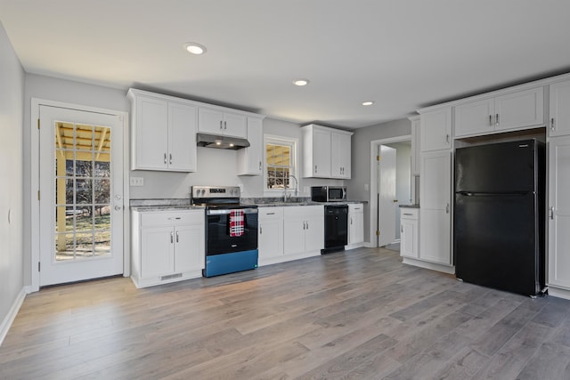 kitchen featuring white cabinetry, sink, light hardwood / wood-style floors, and black appliances