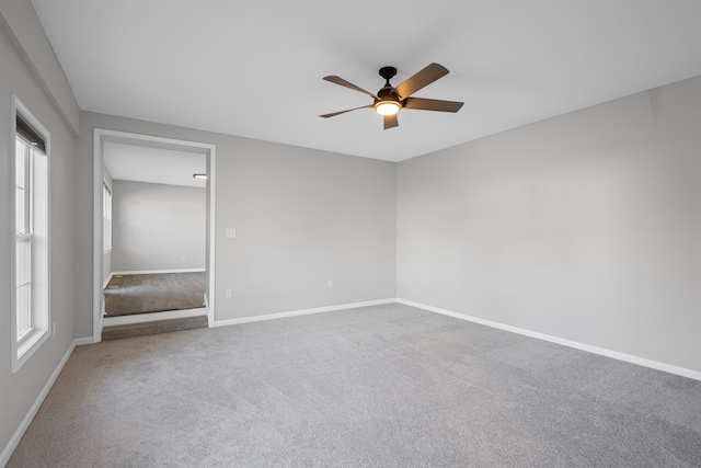 carpeted spare room featuring ceiling fan