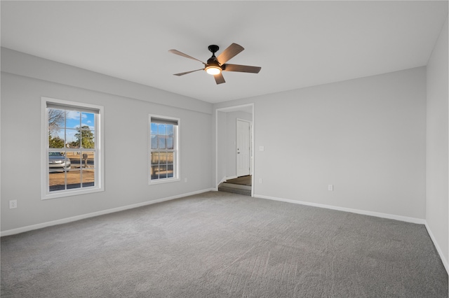 spare room with ceiling fan and carpet