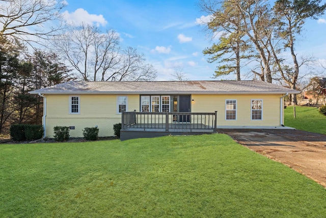 ranch-style home with a deck and a front lawn