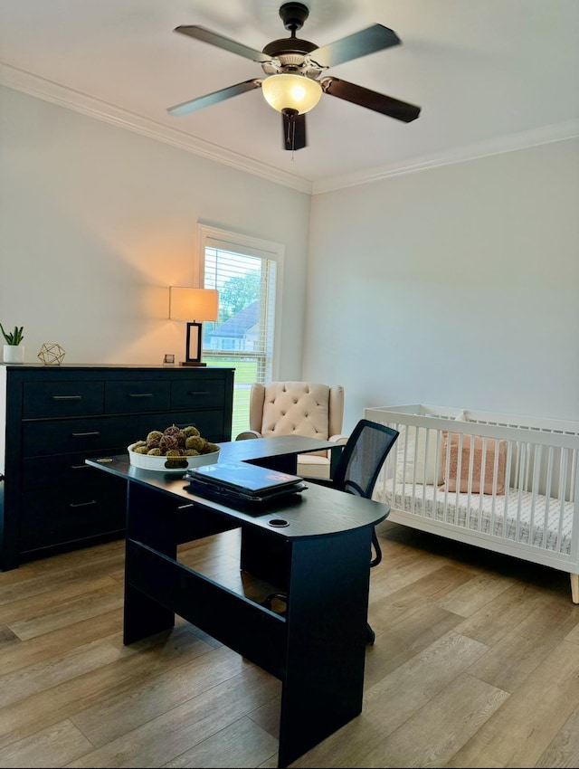 office space with ornamental molding, light wood finished floors, and a ceiling fan